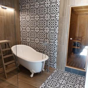 a bath tub in a bathroom with a wall at Suite au château - Domaine de la Gavolerie in Bessé-sur-Braye