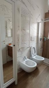 Baño blanco con aseo y lavamanos en La casa di Trilly, en Mola di Bari