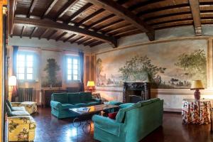 una sala de estar con muebles verdes y una pintura en la pared en Villa Bottini ideale per relax di lusso, en Robecco dʼOglio