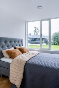 Un dormitorio con una cama con almohadas y ventanas. en Modern Villas in Plush town, en Tromsø