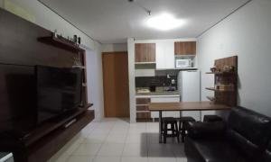 a living room with a dining table and a kitchen at Apto confortável Grand Reserva Casa da Madeira! in Caldas Novas