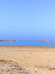 uma praia vazia com o oceano ao fundo em Villa Carol "Ortensia1" "Ortensia 2" em Tollo