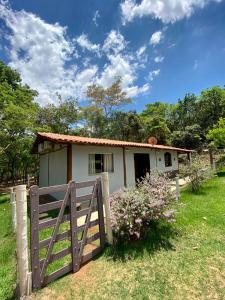 uma pequena casa com um portão e uma cerca em Casa em Área Rural - Delfinópolis em Delfinópolis