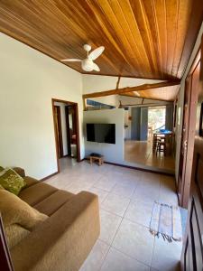 uma sala de estar com um sofá e uma televisão de ecrã plano em Casa em Área Rural - Delfinópolis em Delfinópolis