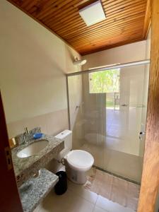 a bathroom with a toilet and a sink and a shower at Casa em Área Rural - Delfinópolis in Delfinópolis