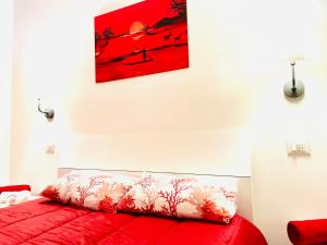ソットマリーナにあるCasa Normaの壁画のある部屋の赤いソファ
