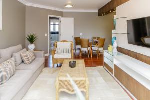 ein Wohnzimmer mit einem Sofa und einem Tisch in der Unterkunft LOCAR-IN GRAMADO - Garibaldi RC a 30m Rua Coberta - Garibaldi RC a 30m Rua Coberta in Gramado