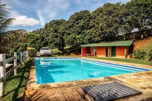 a swimming pool in front of a house at Chalé das Águas in Igaratá