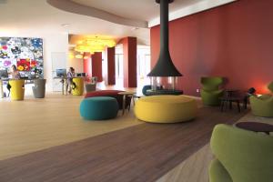 - un hall avec des tables et des chaises colorées dans l'établissement HÔTEL C SUITES chambres spacieuses, à Nîmes