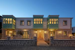 a large house with a stone wall at Çiğdem'inn Sığacık (Cigdeminn Sigacik) in Siğacık