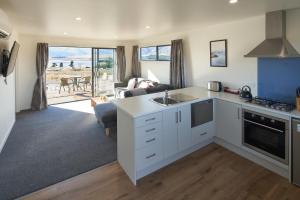 a kitchen and living room with a view of the ocean at Alpine View Apartment 1 - Tekapo in Lake Tekapo