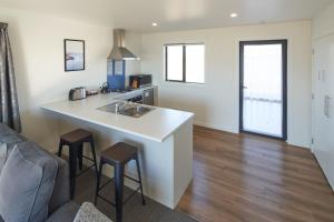 a kitchen with a sink and a counter with stools at Alpine View Apartment 1 - Tekapo in Lake Tekapo