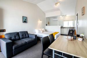 a living room with a couch and a bed at Aura Accommodation in Rotorua