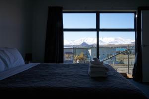 a bedroom with a bed with a view of snow covered mountains at Alpine View Apartment 2 - Tekapo in Lake Tekapo