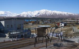 a table and chairs on a deck with snow covered mountains at Alpine View Apartment 2 - Tekapo in Lake Tekapo
