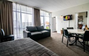 Aura Accommodation في روتوروا: غرفة معيشة مع أريكة وطاولة في غرفة