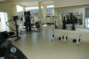 um ginásio com várias máquinas de piso e um espelho em APARTAMENTO ÁGUAS DA SERRA - 005b em Rio Quente