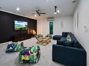 a living room with two couches and a tv at The Palms on Hamilton Island in Hamilton Island