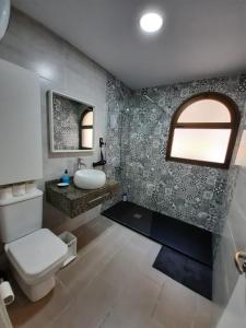 a bathroom with a toilet and a sink and a mirror at FAMILY HOUSE MASPALOMAS II in Playa del Ingles