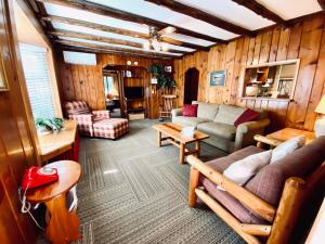 ein Wohnzimmer mit Sofas und Tischen in einem Zimmer in der Unterkunft Foot of the Mountain Motel in Boulder