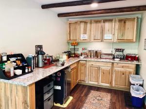 a kitchen with wooden cabinets and a counter top at Foot of the Mountain Motel in Boulder