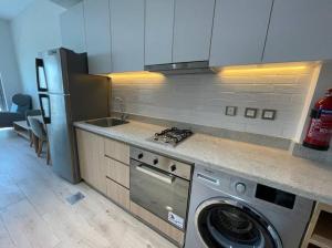 a kitchen with a washing machine and a stove at Hotel Apartment, Studio, Free Swimming Pool, Gym, Kitchen in Dubai