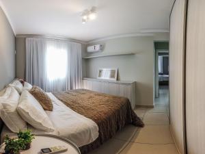 Schlafzimmer mit einem Bett, einem Fenster und einem Tisch in der Unterkunft Apto temático Cerveja - Pomerode SC in Pomerode