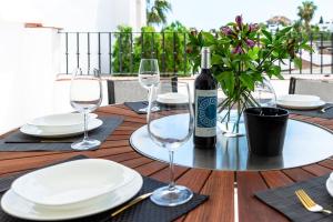 a wooden table with glasses and a bottle of wine at Apartment Señorio de Marbella in Marbella