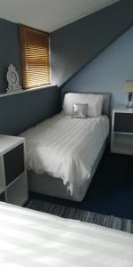 1 dormitorio con cama blanca y pared azul en Northdene Theatre Hotel, en Blackpool
