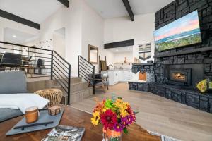 ein Wohnzimmer mit Kamin und Fernseher in der Unterkunft Modern Split Level Cabin -Hot Tub & Game Room in Big Bear City