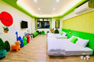 竹山鎮的住宿－晚安熊-親子民宿，一间卧室设有两张床和绿色的墙壁