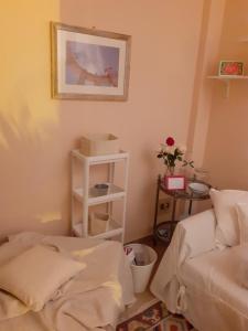 um quarto com duas camas e uma prateleira com uma fotografia em Damiani House em Marsala