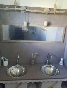 2 lavabos de plata en un baño con espejo en CHARMANT HAUT DE VILLA AVEC PISCINE PARTAGEE, en Le Vauclin