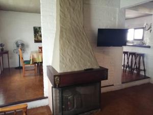 a living room with a fireplace with a tv above it at Uruguay 1014 - Casa y Apartamento - Para 9 personas in Piriápolis