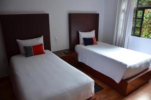 a hotel room with two beds and two lamps at La Casita de Coyoacán in Mexico City