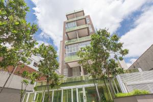 a tall building with trees in front of it at Vossa Bossa VN Turiassu in São Paulo