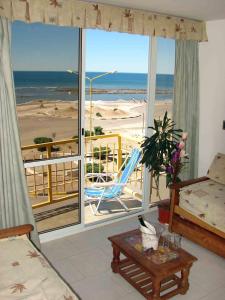 a living room with a view of a beach at Miralmar in Las Grutas