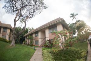 a house with a tree and a grass yard at South Kihei Luxury Condos in Kihei