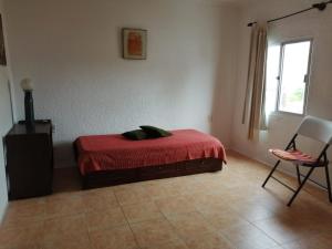 a bedroom with a bed and a chair and a window at Uruguay 1014 - Casa y Apartamento - Para 9 personas in Piriápolis +30 photos