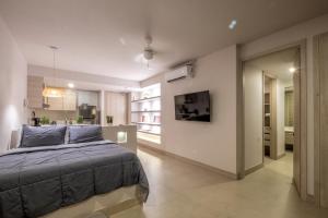 a bedroom with a large bed and a kitchen at Morros ío Serena Del Mar - RNT 95283-523 in Cartagena de Indias