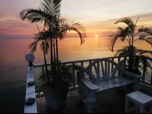 a bench sitting on a deck with a view of the ocean at Karoon hut in Hua Hin