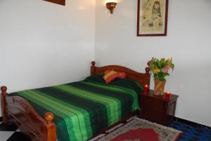 sypialnia z łóżkiem i wazonem kwiatów na stole w obiekcie Résidence Fanti w mieście Sidi Binnzarene