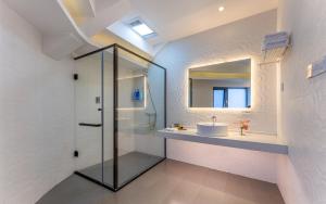 a bathroom with a glass shower and a sink at Xinyue Suying Hot Spring Holiday Hotel in Tengchong +122 photos