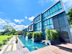an exterior view of a building with a swimming pool at Zensala Riverpark Resort-SHA Extra Plus in Chiang Mai