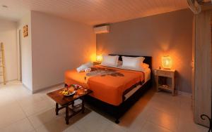 1 dormitorio con 1 cama grande y 1 mesa en Manaeva lodge en Faaa