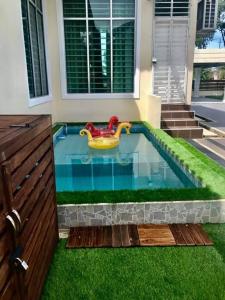 a swimming pool with a toy tub in the grass at AmVilla in Kota Bharu