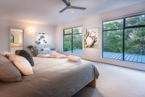 a bedroom with a large bed and two windows at Carpe Vino - quiet bushland home, Margaret River in Margaret River Town