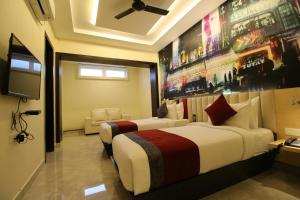 a hotel room with two beds and a flat screen tv at The Butterfly Luxury Serviced Apartments in Visakhapatnam
