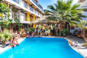 un groupe de personnes assises autour d'une piscine dans l'établissement Banana's Adventure Hostel, à Ica