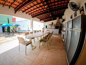 a kitchen with a table and chairs and a refrigerator at Hostel e Pousada Bahia Beach in Itanhaém